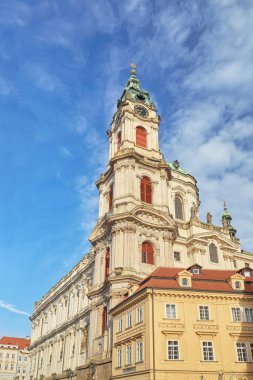 Prag 'daki parlak mavi gökyüzüne karşı tarihi St. Nicholas Kilisesi' nin dikey alçak açılı görüntüsü.