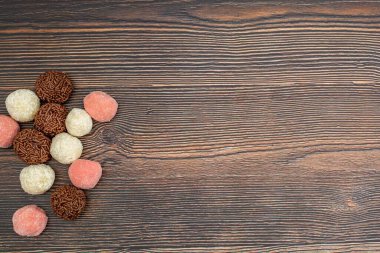 Çikolatalı Brezilya Brigadeiro, Beiginho ve Bicho de Pe 'nin ahşap bir masa üzerindeki fotokopi alanı manzarası.