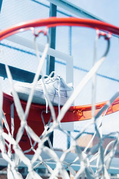 一只白色耐克运动鞋在篮筐上的垂直镜头 — 图库照片