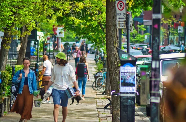 在一个美丽的日子里 一群人在蒙特利尔的一条繁忙的街道上走在人行道上 — 图库照片