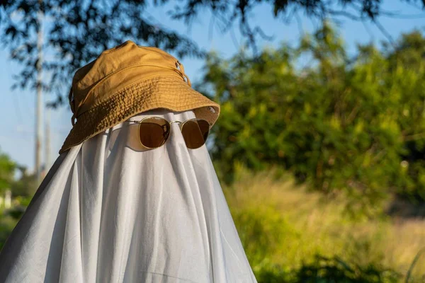 Человек Покрытый Белым Листом Солнечных Очках Шляпе Виде Призрака Саду — стоковое фото