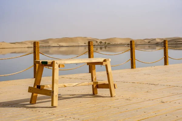湖の背景には ドックの上に空の木製のベンチ — ストック写真