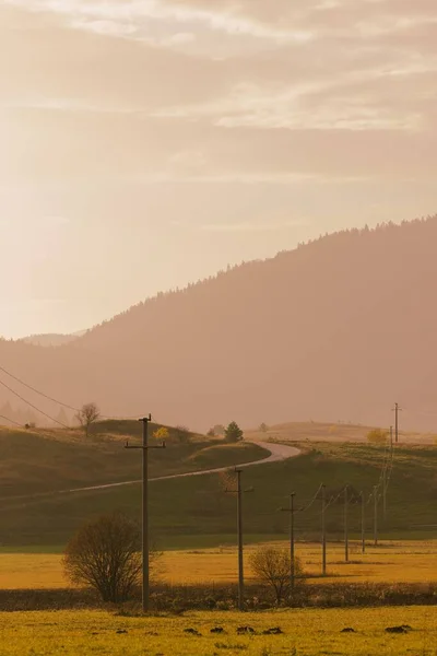 背景には 送電線や駅のある畑 霧の多い山や空の垂直 — ストック写真