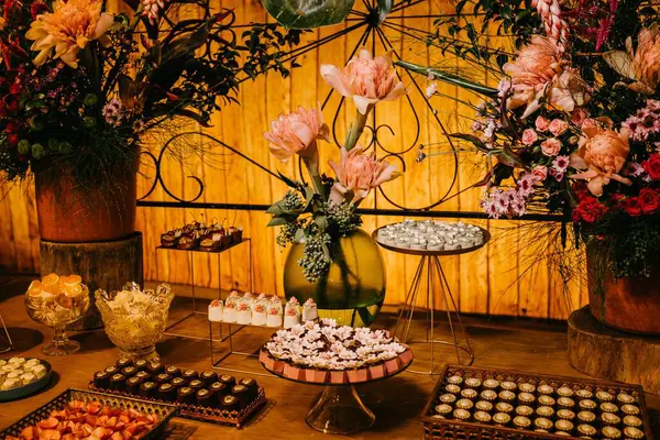 一张木制桌子 上面有新鲜美味的糖果和鲜花 — 图库照片