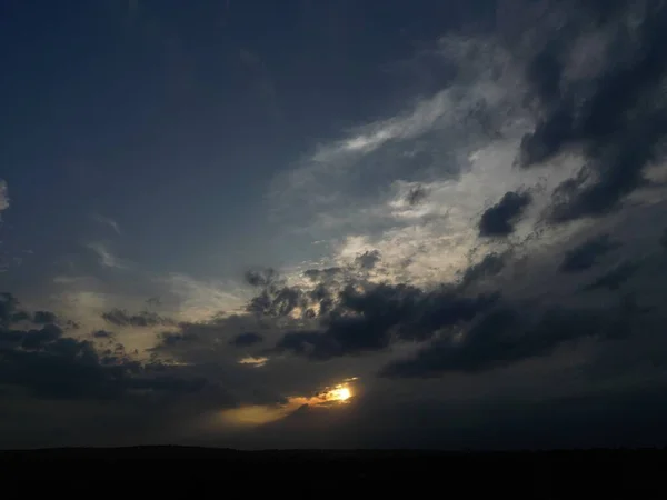 アフリカの日没時に暗い雲の後ろの太陽の風光明媚なショット — ストック写真