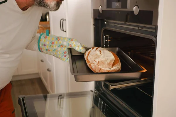Pria Yang Lebih Tua Dengan Jenggot Menempatkan Roti Dalam Oven — Stok Foto