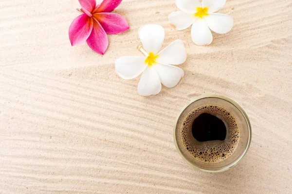 Průhledný Skleněný Hrnek Kávou Espresso Bílými Růžovými Květy Plumeria Písku — Stock fotografie