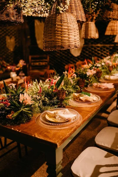 Ένα Ξύλινο Τραπέζι Πολλά Πιάτα Και Λουλούδια — Φωτογραφία Αρχείου