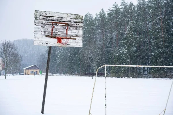 雪の地面と木がある冬のバスケットボールのフープ 背景の空 — ストック写真