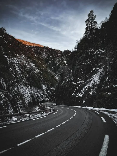 근처의 눈덮인 바위틈 근처에 아스팔트길을 수직으로 — 스톡 사진