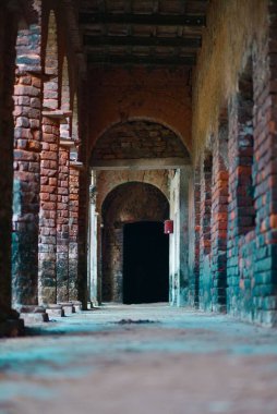 Eski renkli tuğlalı bir binanın girişinin dikey görüntüsü.