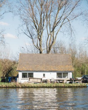 Güneşli bir günde, nehir kenarında modern bir ev.