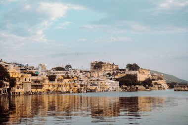 Hindistan 'ın Nathdwara kentindeki sulara yansıyan binalarla göller şehrinin manzara görüntüsü.