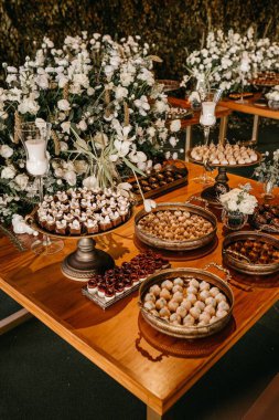 Lokantadaki ahşap bir masanın üzerinde düğün yemeği çeşitlerinin dikey görüntüsü.