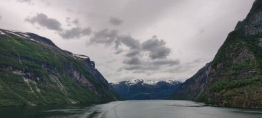 Norveç 'in daha fazla og Romsdal bölgesinde, Sunnmore bölgesinde bulutlu gökyüzü altında Geirangerfjord fiyordunun manzarası