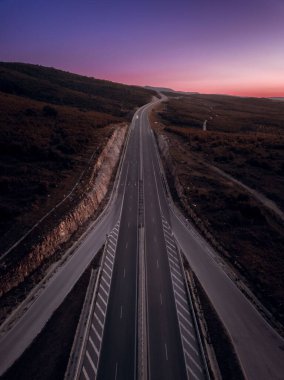 Gün batımında yeşillikte bir otobanın havadan görünüşü