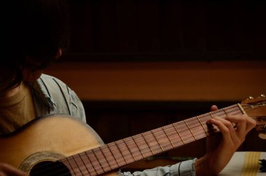 Klasik gitar çalan bir kişi.