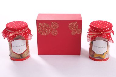 Noel çöreği bisküvileriyle dolu iki kavanozun yakın çekimi. Kutulu kırmızı bir bezle kaplı.