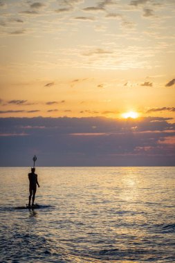 Bulgaristan 'ın Varna kentinde güneş doğarken manzaralı bir deniz manzarasında yakalanan Kral Neptün heykelinin dikey görüntüsü
