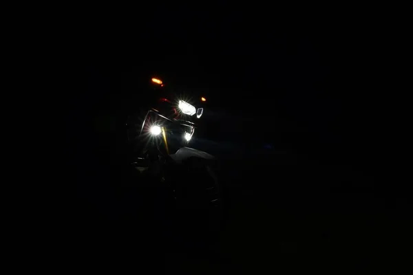 摩托车在黑暗中夜间开着灯 — 图库照片