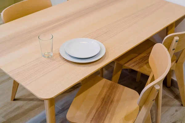 Λευκά Πιάτα Και Ένα Άδειο Ποτήρι Ξύλινο Τραπέζι — Φωτογραφία Αρχείου