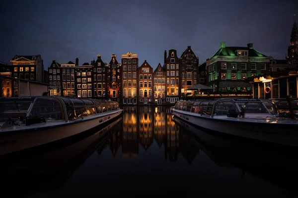 阿姆斯特丹一些夜间俯瞰尼罗河中船只的建筑物的景观 — 图库照片