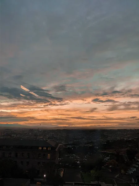 Una Toma Vertical Hermosa Puesta Sol Sobre Ciudad Con Colinas —  Fotos de Stock