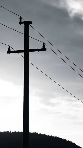 送電線や駅周辺 山や日当たりの良い空の背景を持つフィールドのグレースケール — ストック写真