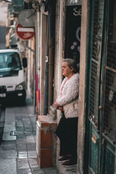 ポルトガルのポルトの通りに立っている老婦人の垂直ショット — ストック写真