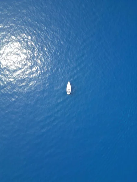 A top view of a boat sailing in the blue lake