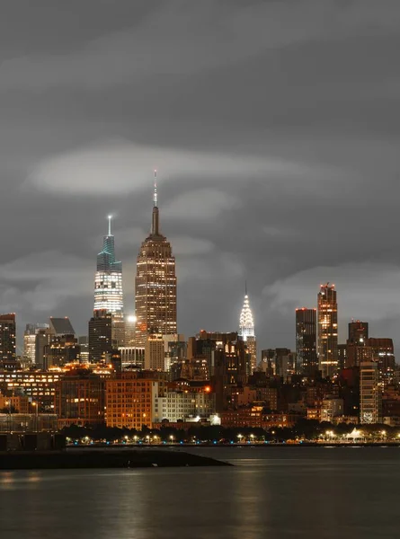 万里无云的一天 纽约市的灯光照亮了帝国大厦与大海相对的垂直面 — 图库照片