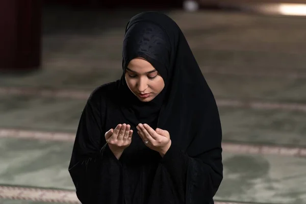 モスクで祈っているヒジャーブの黒いドレスを着た美しいイスラム教徒の女性 — ストック写真