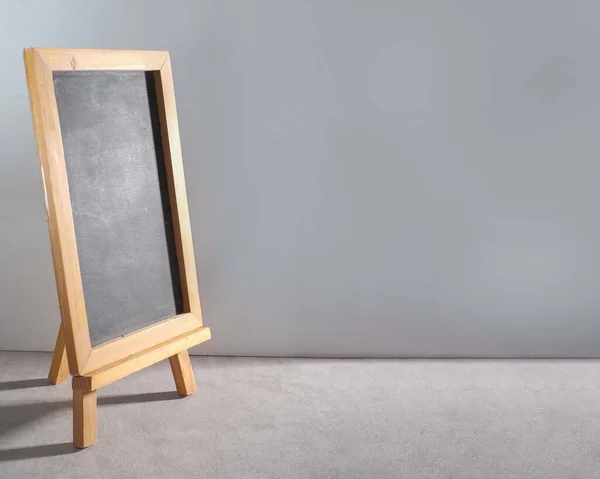 灰色の背景を持つ木製のフレームを持つ空白の黒板のクローズアップ — ストック写真
