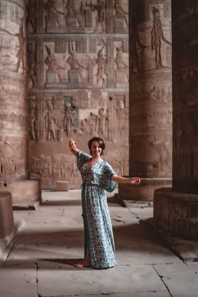 一个穿着夏装的年轻女子在古埃及庙宇里摆姿势的垂直照片 — 图库照片