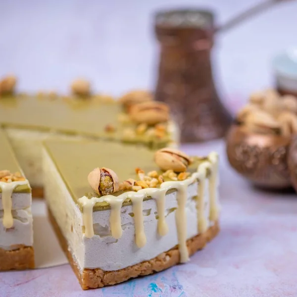 Närbild Bit Cheesecake Med Pistaschkräm Dekorerad Med Pistaschmandlar Och Vaniljkräm — Stockfoto