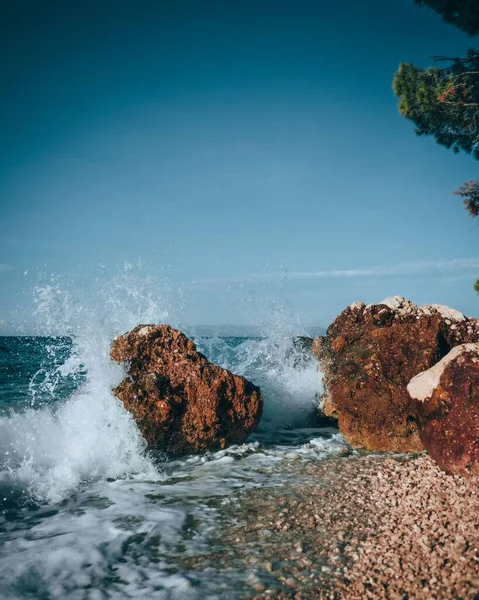 Una Verticale Acqua Che Colpisce Pietre Sulla Spiaggia Cielo Limpido — Foto Stock
