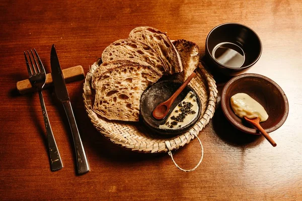 テーブルの上のストロープレートに盛り付けられた焼きたてのパンとスライスされたクラストパンの高角度ショット — ストック写真