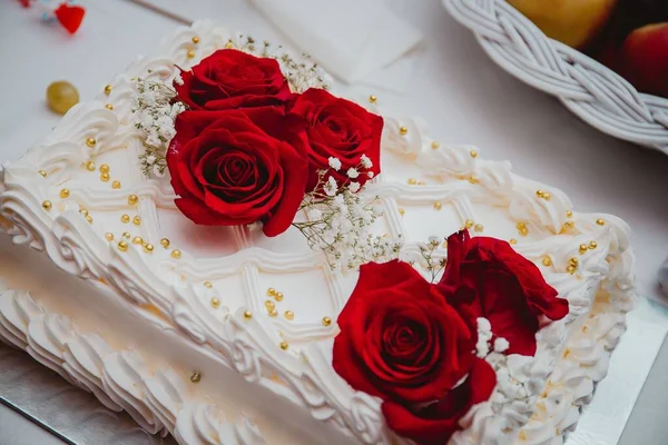 一张用红玫瑰装饰的精致婚礼蛋糕的高角照片 — 图库照片