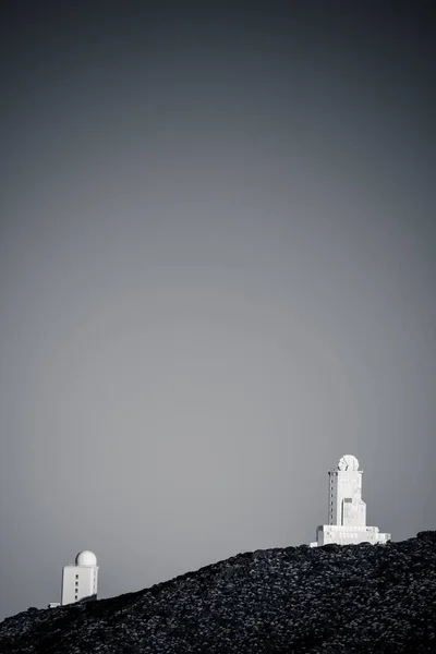 カナリア諸島テネリフェ島の丘の上の近代的な建物の垂直グレースケールショット — ストック写真