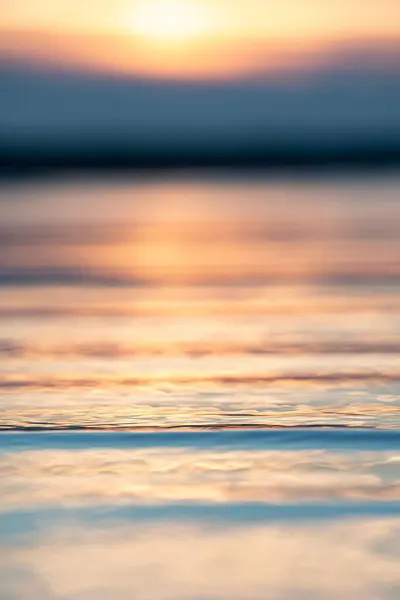 日没の色を反映して水の表面の垂直閉鎖ショット — ストック写真