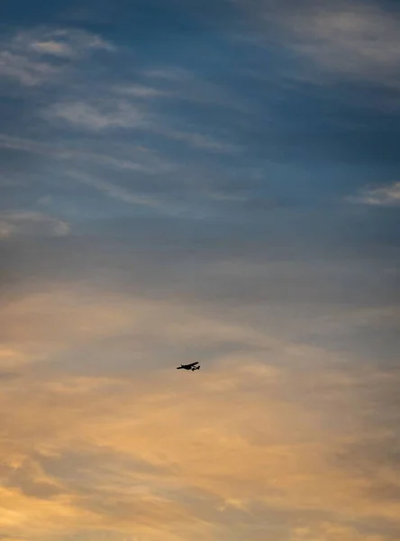 天空中带着云彩的飞机在日落时垂直飞行的镜头 — 图库照片