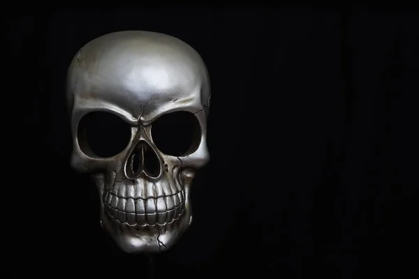 stock image A closeup of the silver metal skull isolated on a black background with a copyspace on the right