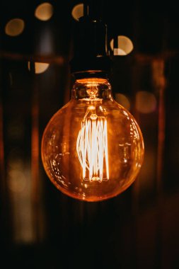 Karanlıkta kablodan sarkan bir ampul.