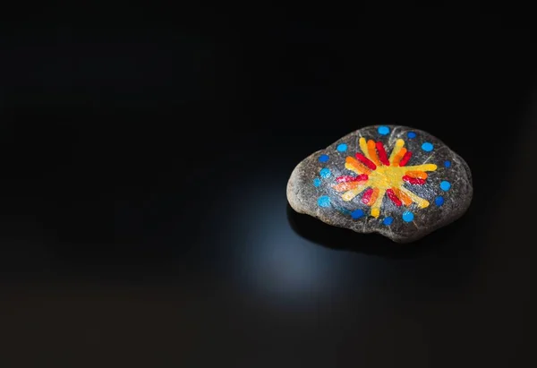 Ein Stein Mit Farbenfroher Malerei Auf Dunklem Hintergrund Mit Platz — Stockfoto