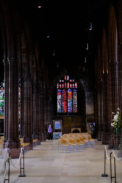 マンチェスター大聖堂の柱付きの廊下タイル張りの床とカラフルなガラス窓 — ストック写真