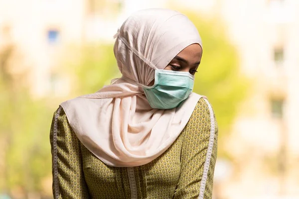 一名年轻的穆斯林妇女带着外科面具和手套在清真寺祈祷 — 图库照片