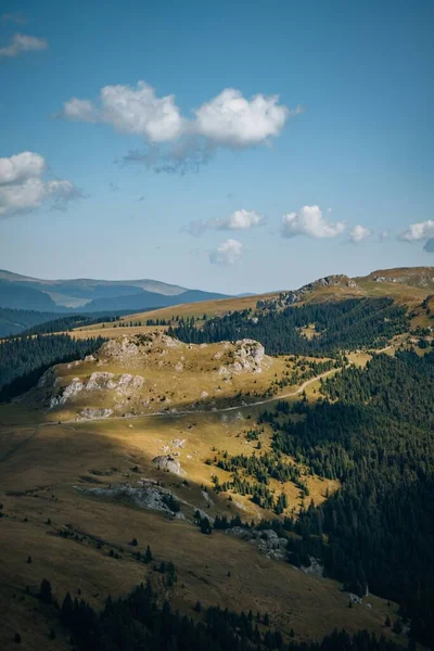 青い空の下で緑の牧草地と岩の丘の空中写真 — ストック写真