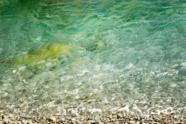 美丽清澈的蓝绿色大海冲刷在鹅卵石沙滩上 — 图库照片