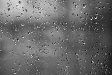 Yağmurlu bir günde cam pencereye düşen yağmur damlaları