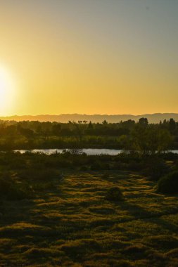 Nehir ve tepelerle birlikte güneş doğuyor..